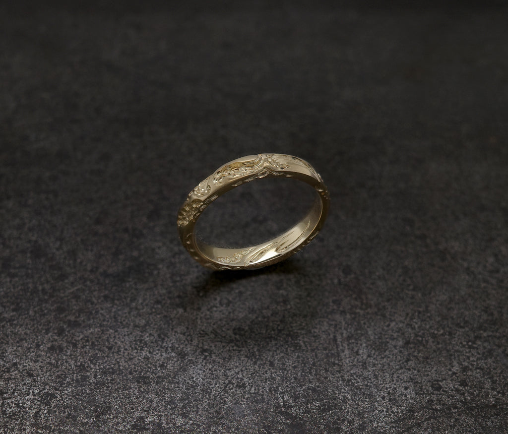 Wave Band (4mm) gold ring with intricate design on a dark background.