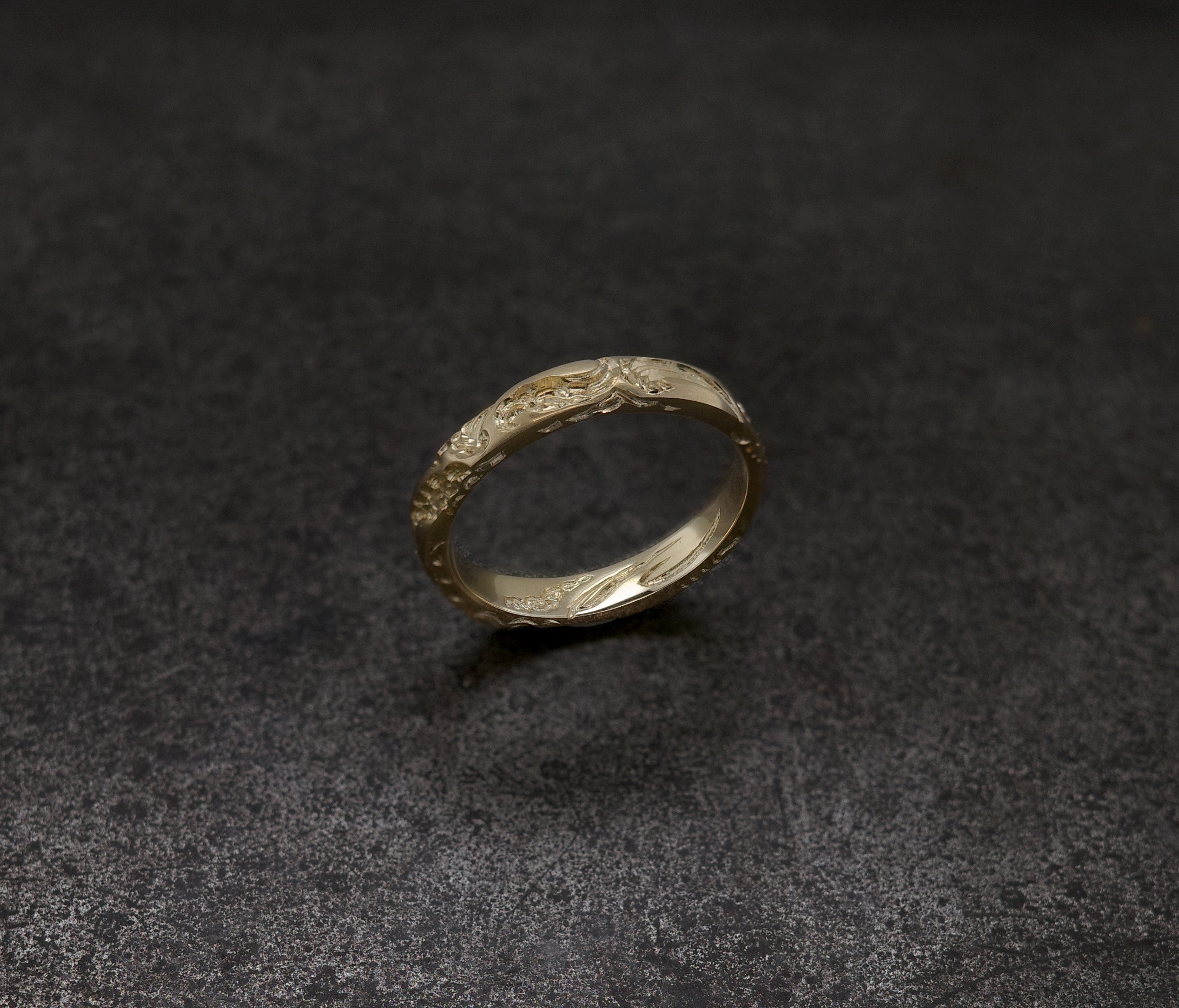 Wave Band (4mm) gold ring with intricate design on a dark background.