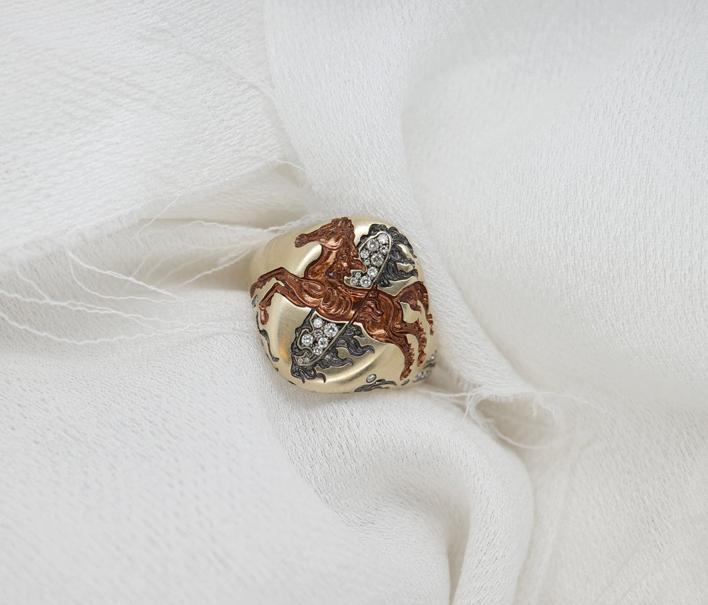 Close-up of a Fire Horse Ring featuring intricate design with sparkling stones on a soft white background.