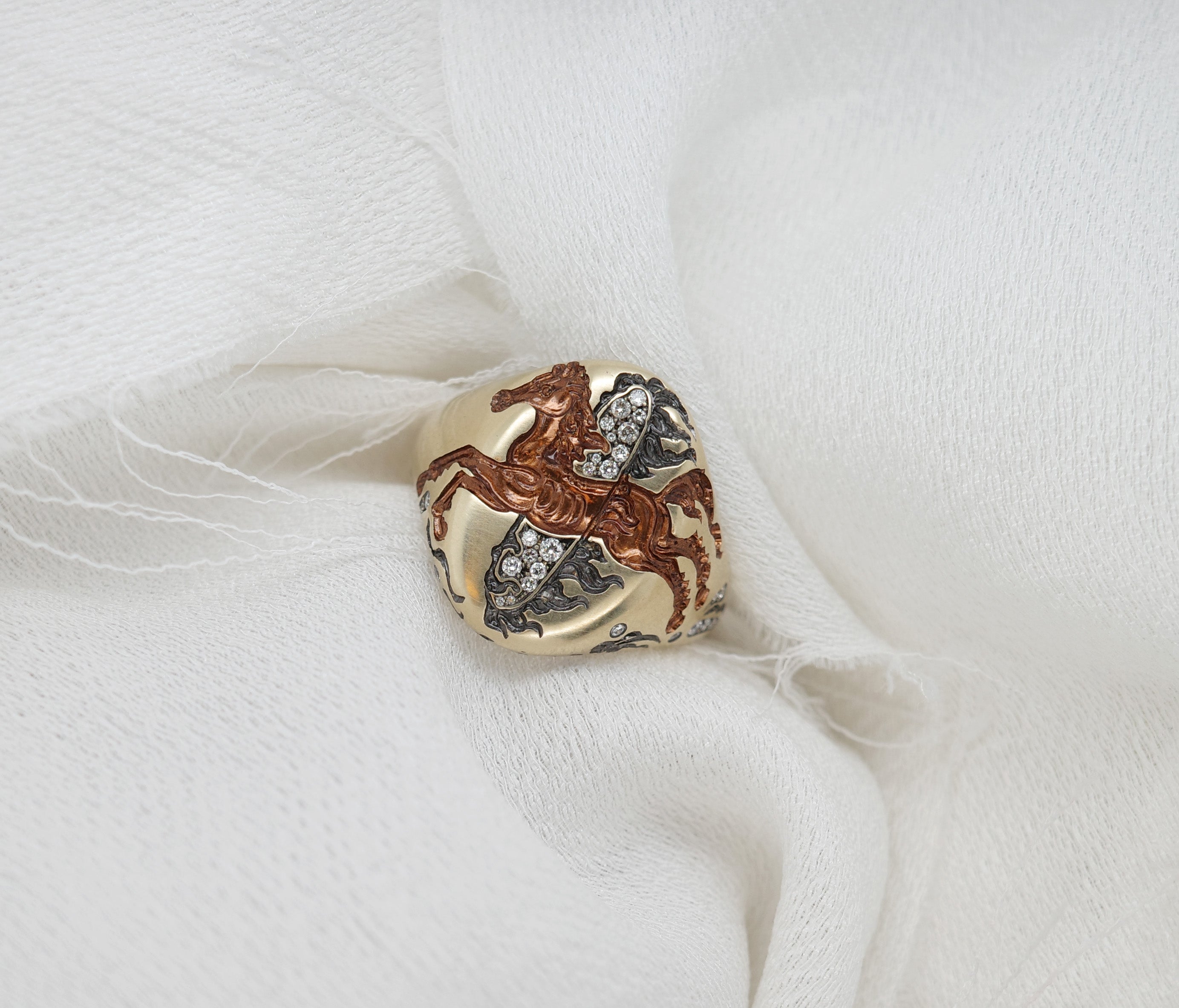 Close-up of a Fire Horse Ring featuring intricate design with sparkling stones on a soft white background.