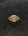 E Minor Signet Ring in gold with intricate design and custom initials on a textured background.