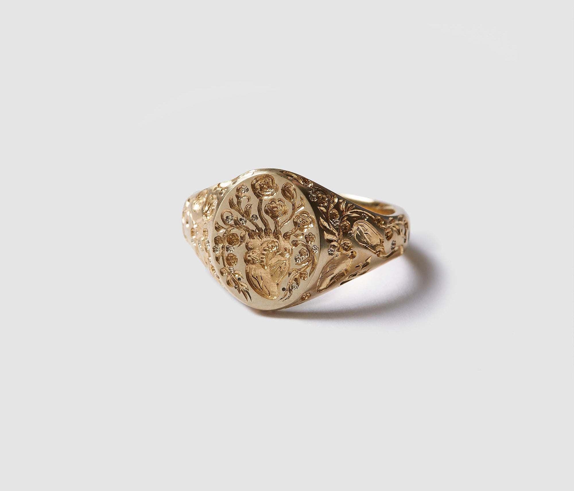 Gold Heart Signet Mini ring with intricate floral and heart design on oval face, symbolizing healing and thoughtful energy