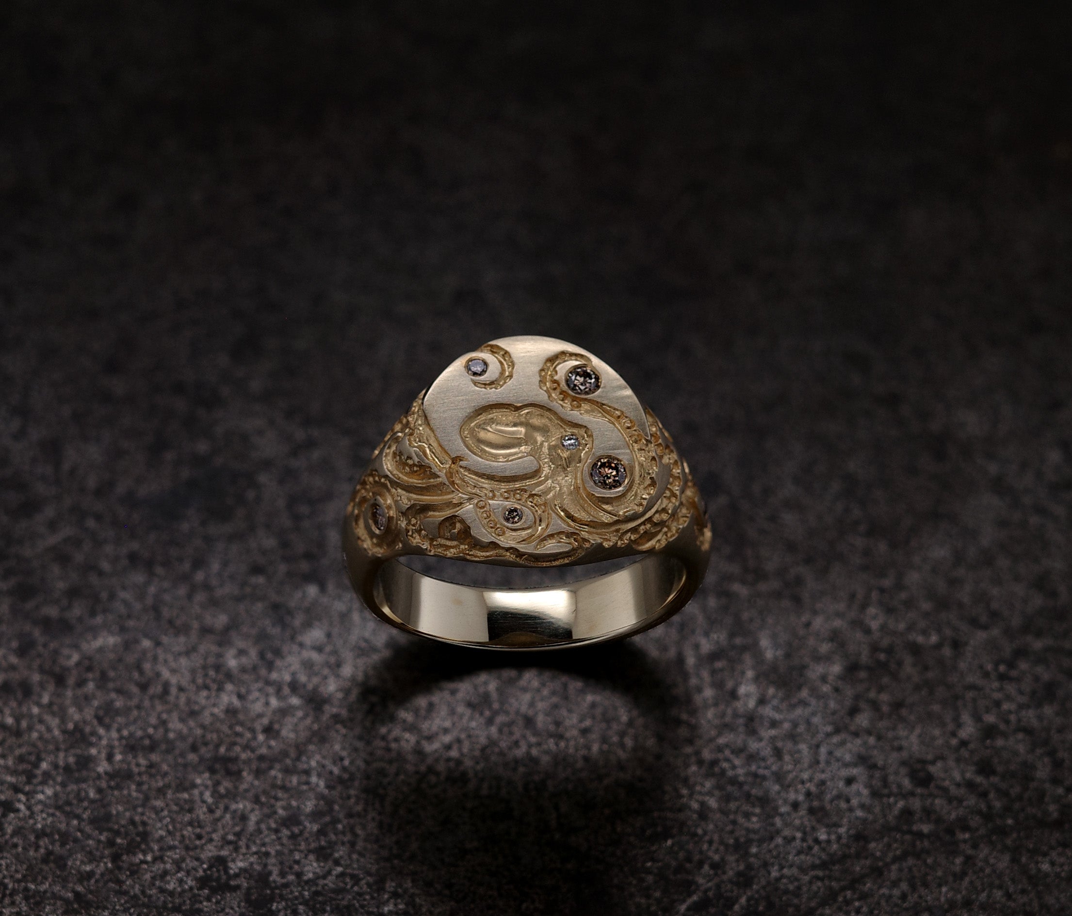 Mini Octopus Signet Ring featuring hand-engraved octopus design with rubies and diamonds on a silver band.