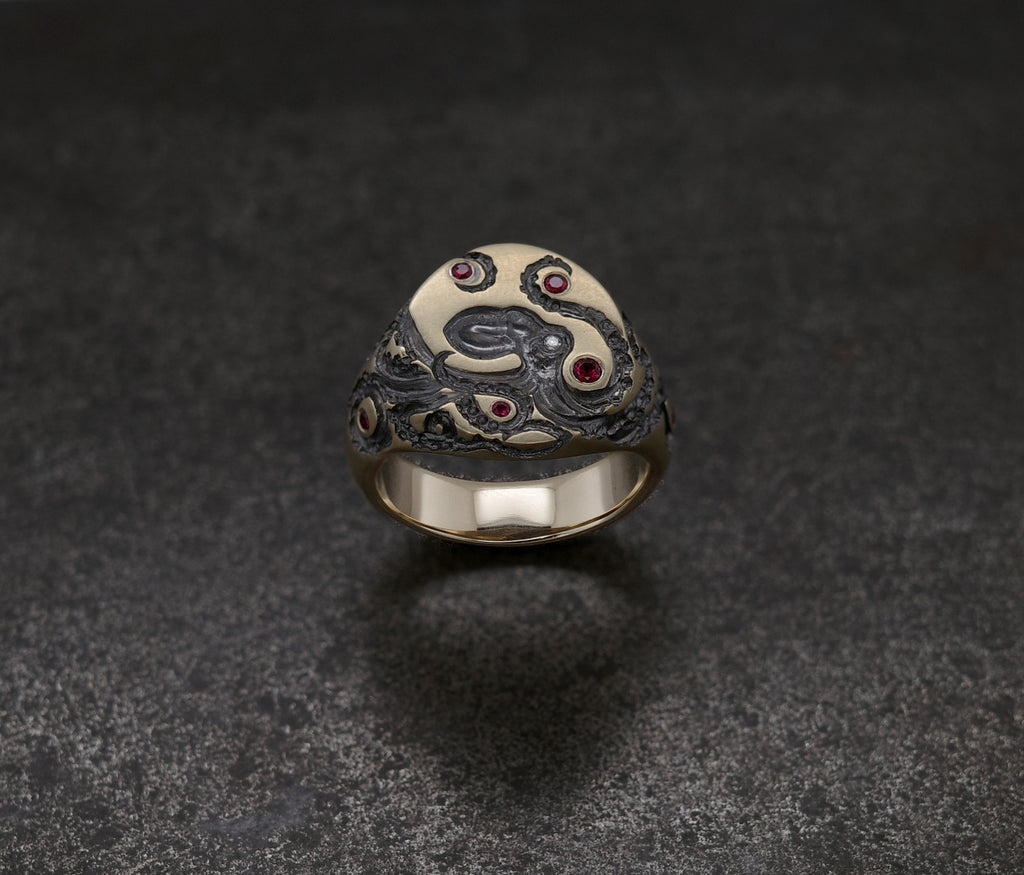 Mini Octopus Signet Ring featuring hand-engraved octopus and rubies on an artistic design.