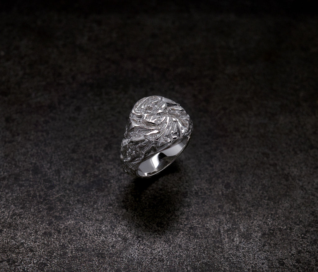 Mini Chisel Signet ring with intricate crystalline chiseled design on a dark background.