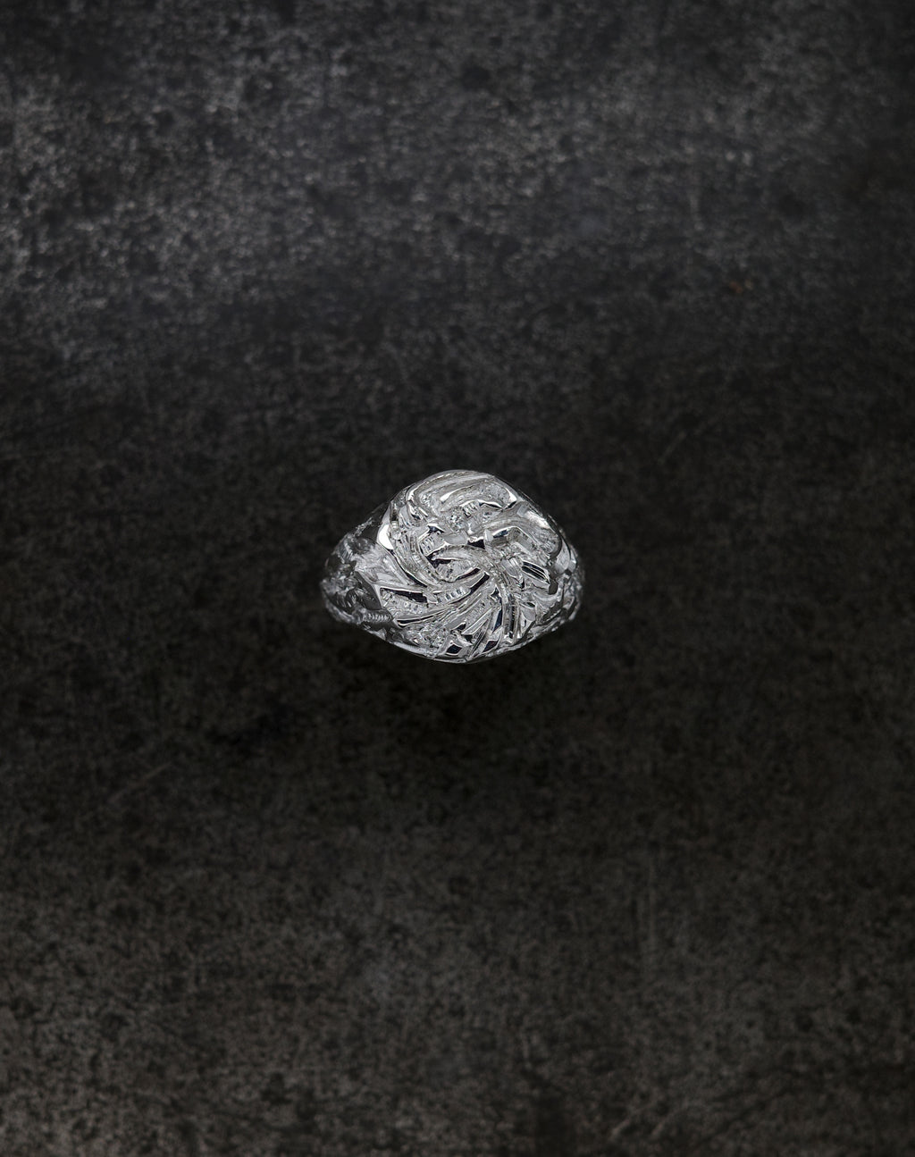 Mini Chisel Signet ring featuring an intricately chiseled crystalline design on a dark background.