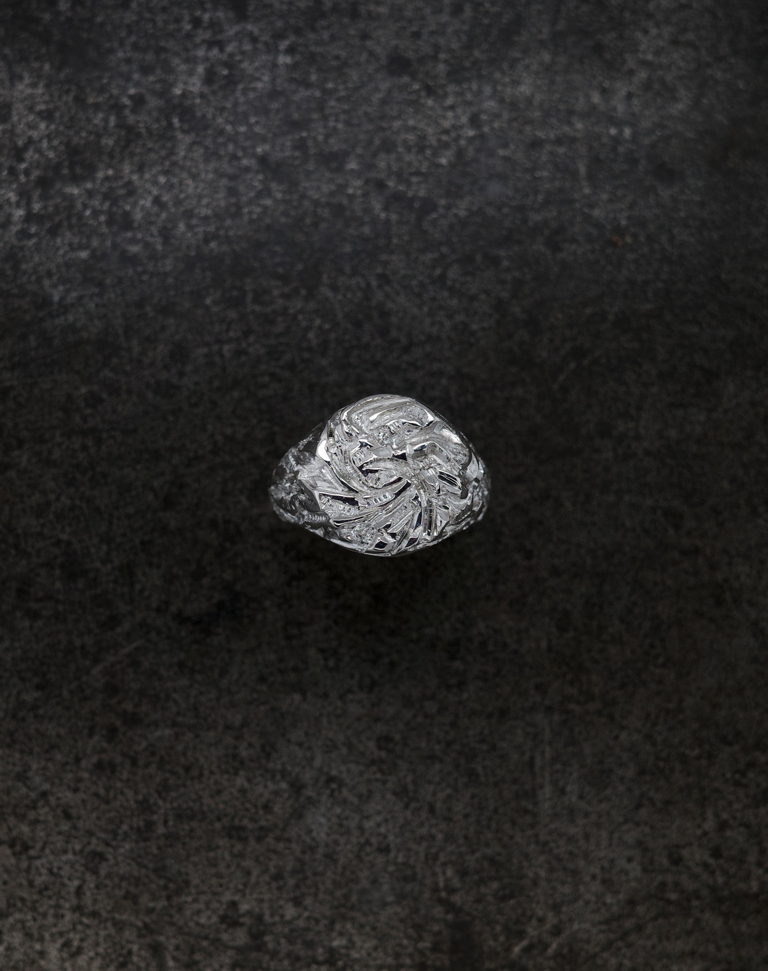 Mini Chisel Signet ring featuring an intricately chiseled crystalline design on a dark background.