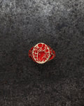 Mini heart signet ring with red floral and anatomical heart design on textured dark background