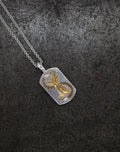 Silver necklace with a detailed Apple Core pendant featuring cognac diamond accents on a dark textured background