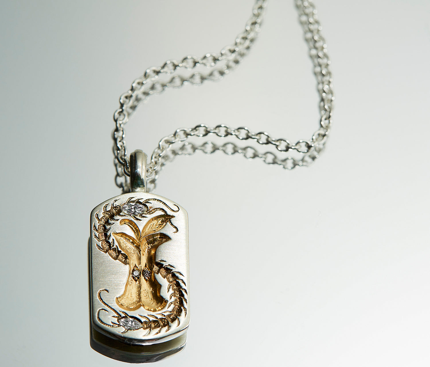 Silver pendant necklace featuring a detailed cognac diamond apple core with a diamond-tipped centipede design