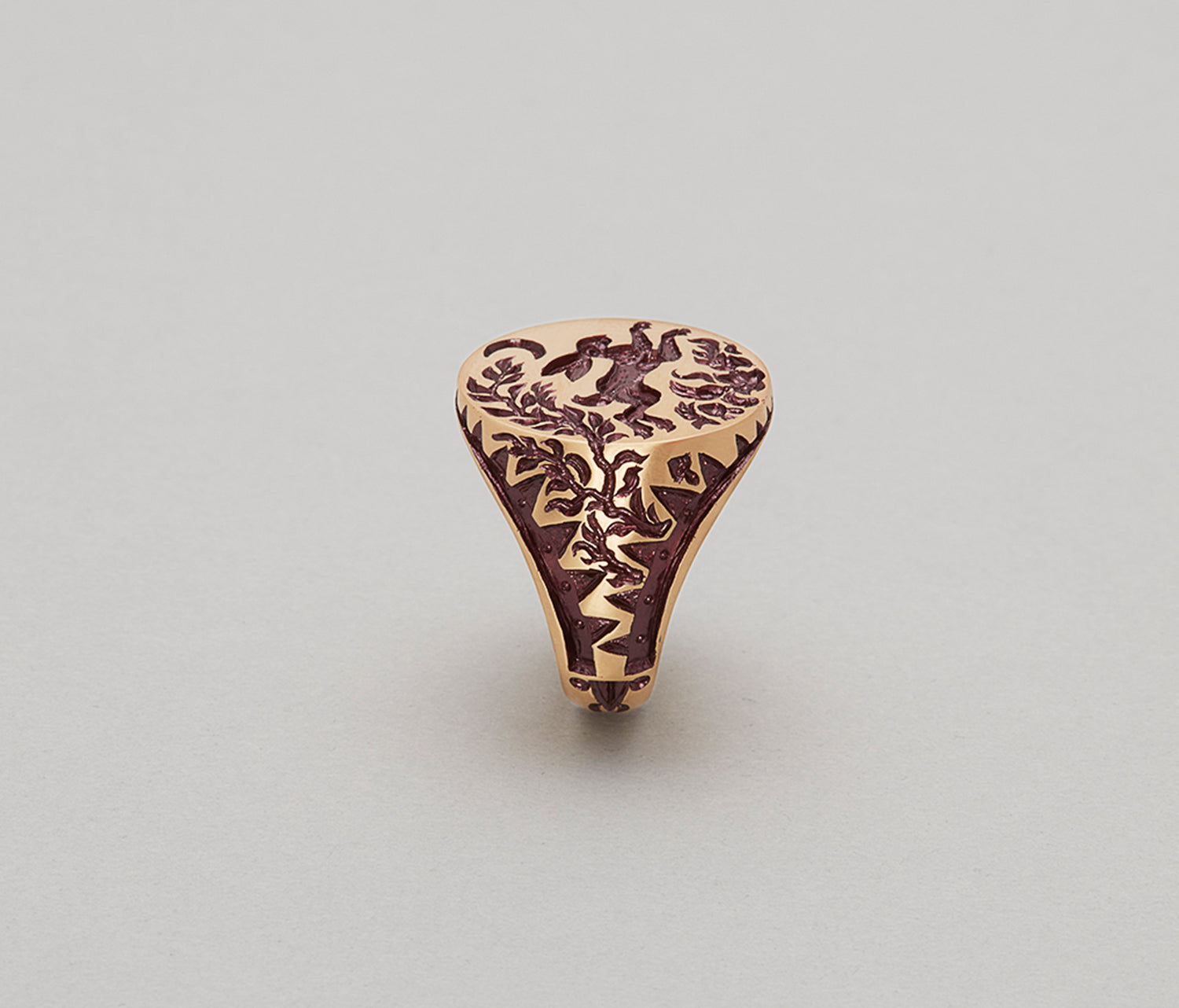 Close-up of a gold Hare & Trap signet ring with detailed engraving of a hare escaping a trap under the moon.