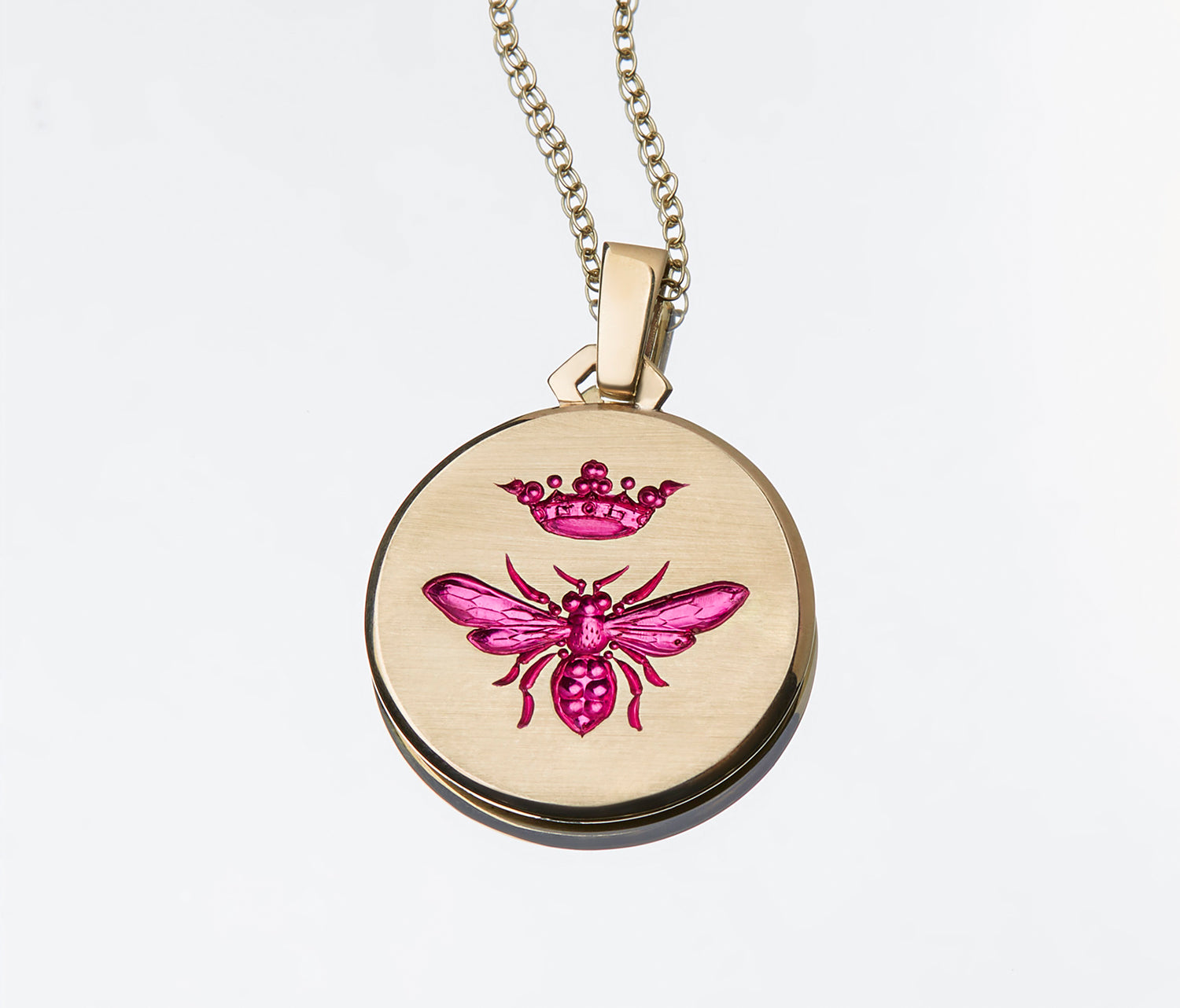 Gold Queen Bee pendant with pink enamel bee and crown design on a chain necklace against white background