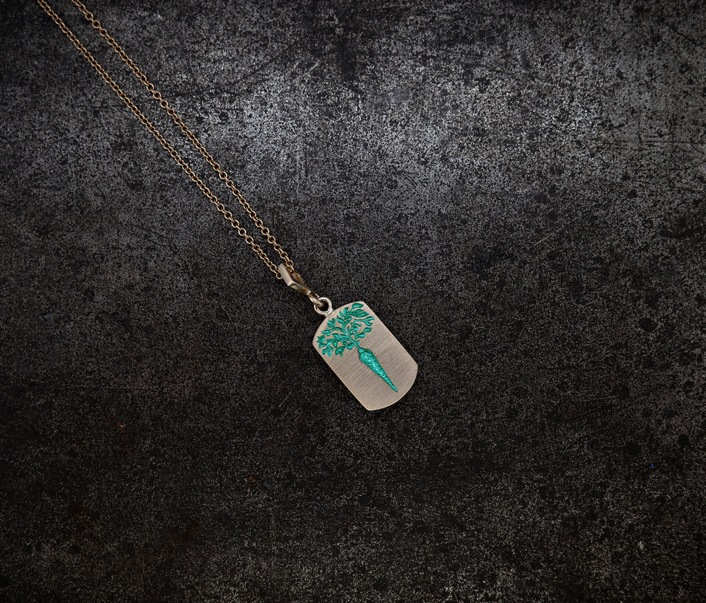 Gold chain necklace with a ceramic-plated rectangular pendant engraved with a turquoise carrot design