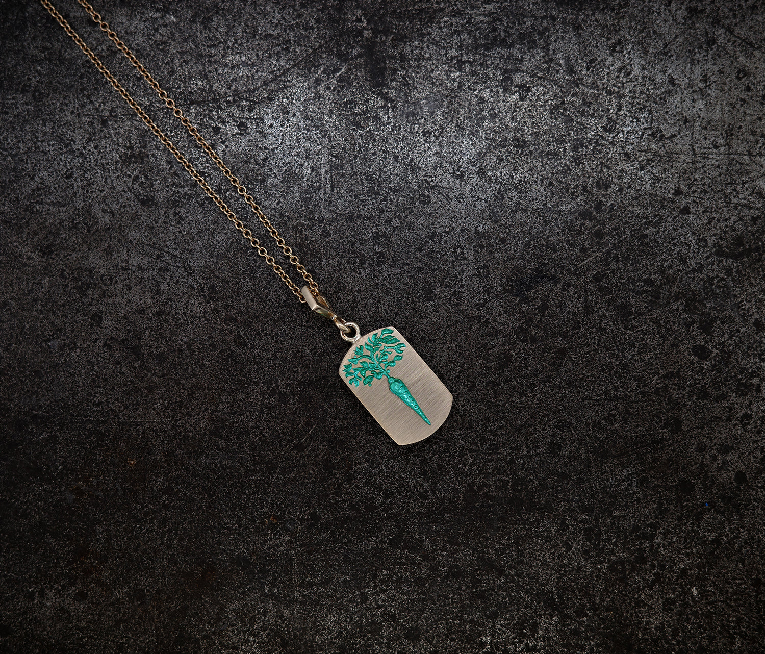 Gold chain necklace with a ceramic-plated rectangular pendant engraved with a turquoise carrot design